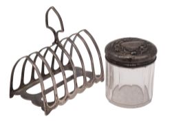 A George V silver toast rack, shaped rectangular, with seven arched bars and a central handle,