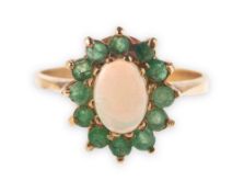 An emerald and opal cluster ring, claw set to the centre with an oval opal cabochon,