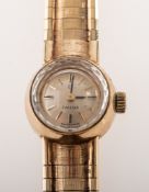 Omega a lady's 9K gold wristwatch the dial with diamonds inset to the bezel and having raised baton
