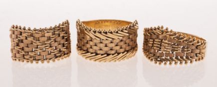 Three 14ct gold articulated rings of varied design, each with an articulated woven front panel,