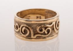 A 9ct gold band ring, with a textured and polished scrolling design to the front section,