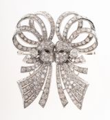 A splendid Art Deco diamond brooch and dress clips, of scrolling openwork ribbon and bow form,