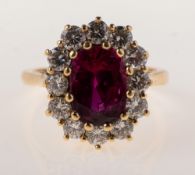 An 18ct gold ruby and diamond ring, of oval cluster form,