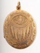 An antique gilt oval locket, with ornately carved decoration to both sides, unmarked yellow metal,