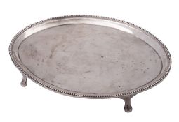 A George III silver teapot stand, of navette outline, with a bead border and on pad feet,