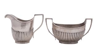 A George V silver sugar basin, oval form, with a fluted lower body and twin, angular handles,