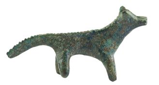 A GREEK BRONZE MODEL OF A CANINE, GEOMETRIC PERIOD, CIRCA 7TH CENTURY B.C.