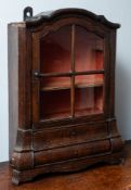 An oak and glazed table cabinet in the form of a miniature Dutch bombe display cabinet,