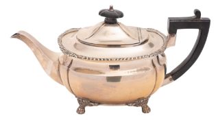 A George V silver tea pot, of shaped oblong form, with a gadroon & shell border,