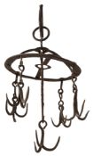 A wrought iron game hanger; with a central three-hook terminal suspended on a writhen stem,