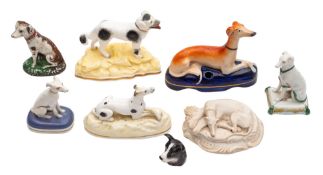 A group of porcelain dog figures including a Staffordshire porcelaneous example,