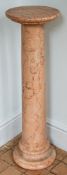 A pair of pink mottled stone pedestals,