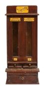 A stained wood, glazed and brass mounted cigarette vending machine,