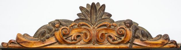 A carved beechwood overdoor, modern; modelled with trailed scrolling foliage,