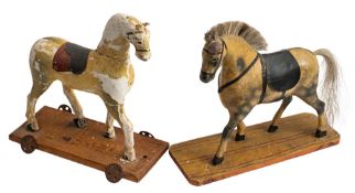 A late 19th/early 20th century child's wooden pull-along horse, together with one other similar,