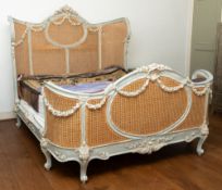 A pair of carved and painted wood and canework double beds in Louis XV taste,