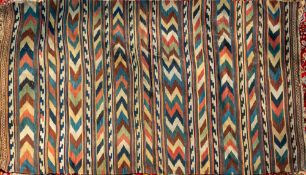 A Persian flatweave kilim carpet, 20th century; with rows of chevrons in green, red, brown,