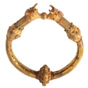 A WESTERN ASIATIC YELLOW METAL BRACELET, AFTER THE ANTIQUE the terminals in the form of bulls,