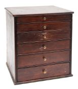A stained wood table top collector's cabinet,