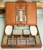 A George V pigskin cased travelling dressing set;