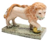 A pearl ware figure of the Medici lion with raised tail and one paw resting on a ball,