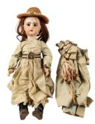 An early 20th century bisque head doll, unsigned, brown wig, fixed brown glass eyes,