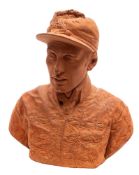 A terracotta bust modelled as a jockey wearing a cap and racing silks, 30cm high,