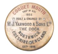 A circular brass builder's plaque for the Warkworth Harbour Commissioners dredger 'Coquet Mouth',