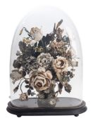 An early 20th century painted composition floral spray under glass dome, on a ebonised scocle,