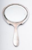 A George V silver hand mirror, with engine-turned decoration and monogrammed,