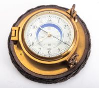 A brass bulkhead clock by Nauticalia, the white dial with Arabic numerals and subsidiary tide dial,