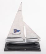 A Royal Ulster Yacht Club aluminium trophy in the form a a stylized yacht with applied club emblem