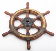An 18 inch teak and brass ship's helm, unsigned, central iron boss with block and turned spars..