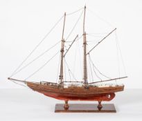 A scale model of a brig, standing rigged over simulated plank deck with winches and fittings,