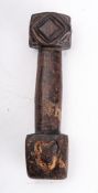 A 19th century treen seam rubber, with geometric carved pommel and heart decorated head,
