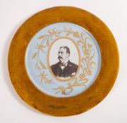 A portrait of a Victorian gentleman set within a ceramic plate.