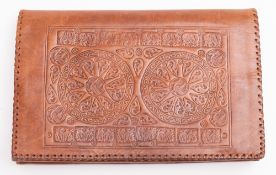 A 1960s North African brown tooled leather clutch bag.