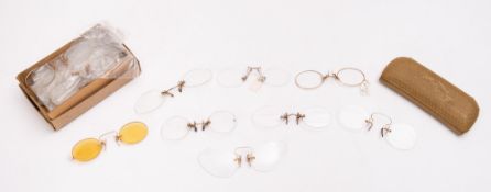 A mixed collection of yellow metal spectacle bridges.