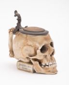 A 20th Century German porcelain and pewter lidded stein in the form of a skull,