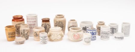 A collection of various stoneware and earthenware pots, including 'Finigan's Nutritive Cream',
