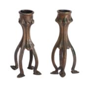 A pair of patinated bronze candlesticks