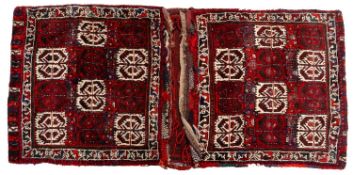 A Turkoman saddle bag, the twin faces with square quartered wine and ivory serrated leaf designs,