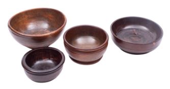 Four turned treen bowls, 19th century; comprising a fruitwood example, 8cm high, 16.5cm diameter
