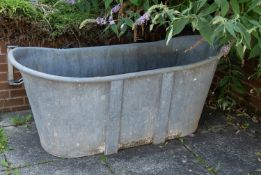 A zinc bathtub, early 20th century; with tapered sides and roll-top edges; 70cm high,