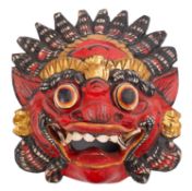 A Balinese carved wooden Barong Rakshasa mask, the fierce visage under brightly painted colours,
