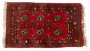 An Afghan Turkoman mat, the wine field with six quartered guls and hooked cruciform lozenges,
