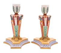 A pair of Royal Worcester porcelain 'Egyptian Revival' candlesticks each with three female