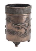 A Chinese bronze cylindrical tripod brush pot cast with mythical beasts and cloud scrolls below and