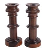 A pair of lignum vitae candlesticks,