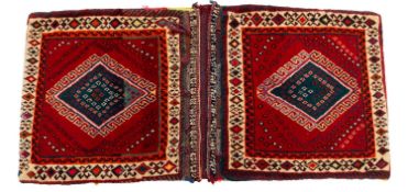 A Turkoman saddle bag, the twin madder faces each with a hooked lozenge medallion,
